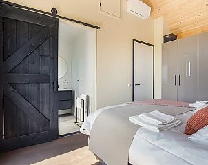 Moderne slaapkamer met badkamer in Huisje in Slappeterp, vakantiehuis op het Friese platteland.