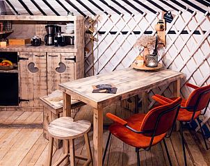 Gezellige binnenruimte in Vakantiehuis in Parrega, Friesland, met houten tafel en moderne keukenfaciliteiten.