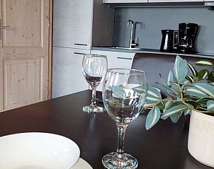 Eettafel in Huisje in Swichum met servies en uitzicht op de keuken, gelegen in Friesland.