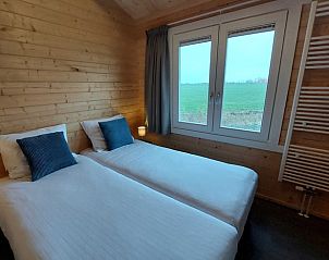 Slaapkamer met twee bedden in Huisje in Swichum, met uitzicht op het Friese platteland, Friesland.