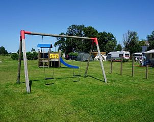 Speeltuin met schommel op het terrein van Huisje in Swichum, ideaal voor gezinnen in Friesland.