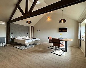 Ruime slaapkamer in Vakantiehuis in Sexbierum met houten details en eethoek, Friesland.