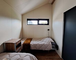 Rustige slaapkamer in Vakantiehuisje in Baaium, Friesland, met uitzicht op de natuur.