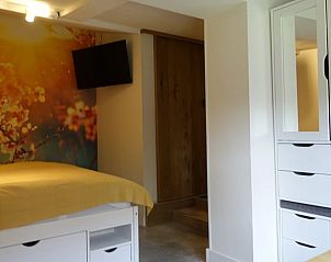 Slaapgedeelte in Vakantiehuisje in Tersoal, Het Friese platteland, met comfortabel bed en decoratief behang.