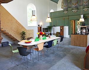 Gezellige binnenruimte van Vakantiehuisje in Easterwierrum, met een lange eettafel en keuken in het Friese platteland.