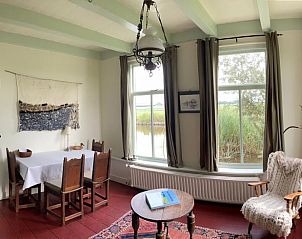 Gezellige eetkamer in Vakantiehuis in Achlum, Friesland, met landelijke inrichting en uitzicht op de natuur.
