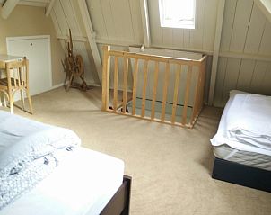 Ruime zolderkamer in Vakantiehuis in Achlum, Friesland, met extra bedden en gezellige inrichting.