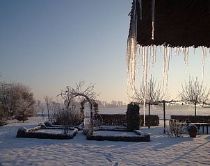 Winterlandschap bij Vakantiehuisje in Gytsjerk met sneeuw en ijspegels op het Friese platteland.