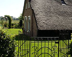 Sfeervolle ingang van Vakantiehuisje in Gytsjerk met smeedijzeren hek en groene tuin.