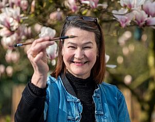 Gast met penseel in de tuin van Vakantiehuisje in Gytsjerk genietend van de natuur.