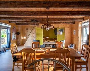 Eethoek in Vakantiehuis in Sint Annaparochie, Friesland, met houten tafel en stoelen, ideaal voor familiediners.