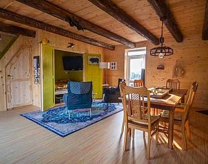 Ruime binnenruimte van Vakantiehuis in Sint Annaparochie, Friesland, met houten balken en moderne inrichting.