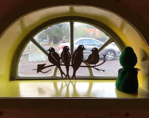 Raamdecoratie met vogels in Vakantiehuis in Sint Annaparochie, Friesland, biedt een charmant uitzicht naar buiten.