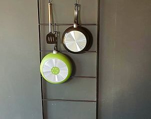 Keukenaccessoires aan de muur in Vakantiehuis in Sint Annaparochie, Friesland, voor een huiselijke sfeer.