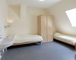 Slaapkamer met twee bedden in Huisje in Sint Annaparochie, ideaal voor een verblijf op het Friese platteland, Friesland.