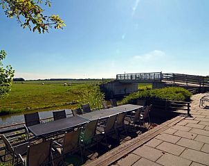Terras met uitzicht op het Friese platteland bij Huisje in Sint Annaparochie, ideaal voor buitenmaaltijden in Friesland.