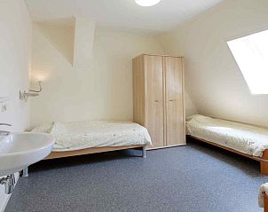 Zolderkamer met houten balken in vakantiehuis FR290, Sint Annaparochie, Friesland.