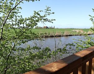 Uitzicht vanaf de veranda van Huisje in Wommels, over het Friese platteland in Friesland.