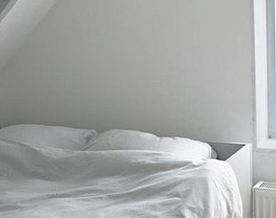 Lichte slaapkamer in Vakantiehuisje in Pingjum met uitzicht op het Friese platteland.