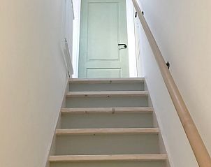 Trap in Vakantiehuisje in Pingjum naar bovenverdieping met rustieke houten details.