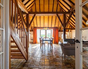 Ruime binnenruimte van Het Koetshuis in Pingjum, Friesland, met houten balken en veel natuurlijk licht.