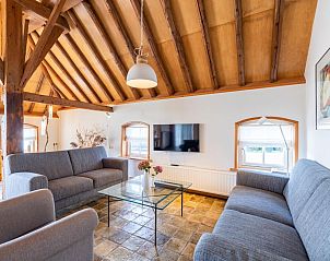 Gezellige zithoek in Het Koetshuis, een vakantiehuis in Pingjum, Friesland, met comfortabele banken en moderne inrichting.