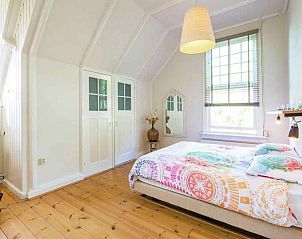 Zonnige serre met comfortabele stoel in vakantiehuis FR020, Sint Jacobiparochie, Friesland.