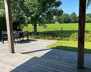 Zonnig terras van Vakantiehuis in Noardburgum met uitzicht op groene weilanden in Friesland.