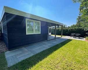 Achterzijde van Vakantiehuis in Noardburgum met grasveld en terras in Friesland.