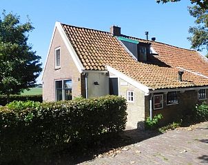 Zijaanzicht van Vakantiehuis in Jannum met groene heggen en landelijke omgeving, Friesland.