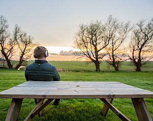 Ontspanning op het terras van Vakantiehuis in Jannum met uitzicht op het Friese platteland, Friesland.