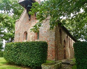 Historisch gebouw naast Vakantiehuis in Jannum, omgeven door groen, Friesland.