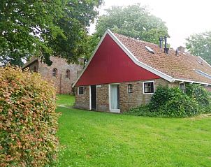 Huisje in Jannum, omgeven door groene natuur op het Friese platteland.
