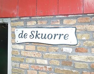 Naambordje 'de Skuorre' op de muur van Huisje in Jannum, vakantiewoning in Friesland.