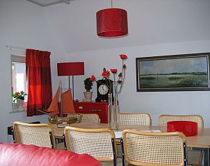 Eethoek van Het Kleine Huis, een bungalow in Lauwersmeer, Friesland, met moderne inrichting en schilderij van Friese natuur.