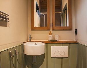 Moderne badkamer in Vakantiehuis in Waskemeer, Friesland met stijlvolle wastafel en spiegel.