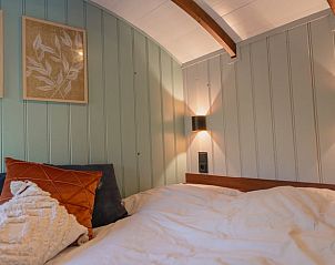 Gezellige slaapkamer in Vakantiehuisje in Waskemeer, Friesland, met sfeervolle wanddecoratie en knusse verlichting op het Friese platteland.