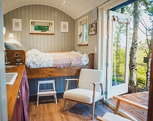 Gezellige binnenruimte van Vakantiehuis in Waskemeer, Friesland, met uitzicht op het Friese platteland vanuit een knusse slaapkamer.