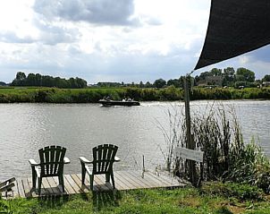 Uitzicht op de rivier vanaf het terras van Vakantiehuisje in Jelsum, Friesland, midden in de natuur.