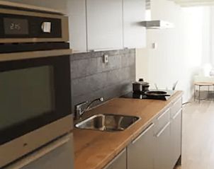 Moderne keuken in Vakantiehuisje in Jelsum, Friesland met inbouwapparatuur en houten werkblad.