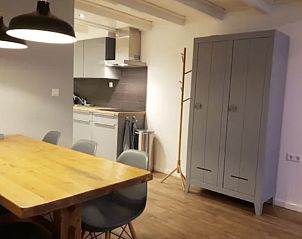 Gezellige eetruimte in Vakantiehuisje in Jelsum, Friesland met houten tafel en grijze kast.