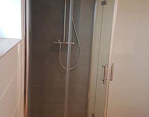 Frisse badkamer in Vakantiehuisje in Jelsum, Friesland met ruime douche en houten accenten.