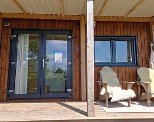 Veranda met comfortabele stoelen bij Vakantiehuis in Jelsum, Het Friese platteland.