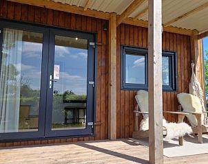 Veranda met uitzicht op natuur bij Vakantiehuis in Jelsum, Friesland.