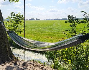 Hangmat bij Vakantiehuis in Jelsum, ideaal voor ontspanning op het Friese platteland.