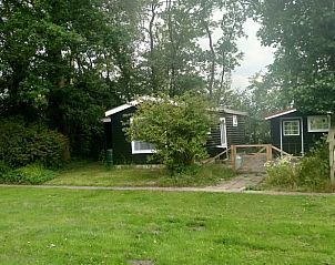 Rustiek vakantiehuisje in Kollumerzwaag omgeven door groen op het Friese platteland.