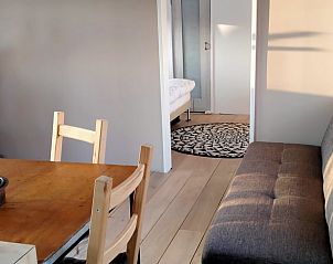 Zithoek en eetkamer in Vakantiehuis in Kollumerzwaag, perfect voor ontspanning op het Friese platteland.