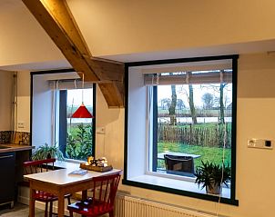 Eethoek met uitzicht in Huisje in Stiens, een vakantiehuis in het rustige Friese platteland, Friesland.