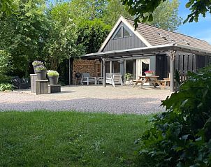 Geniet van de rust bij Vakantiehuisje in Stiens, gelegen op het Friese platteland, met een uitnodigend terras en groene omgeving.