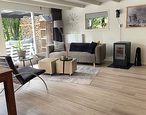 Gezellige woonkamer in Vakantiehuisje in Stiens, gelegen op het Friese platteland in Friesland, met uitzicht op de groene tuin.